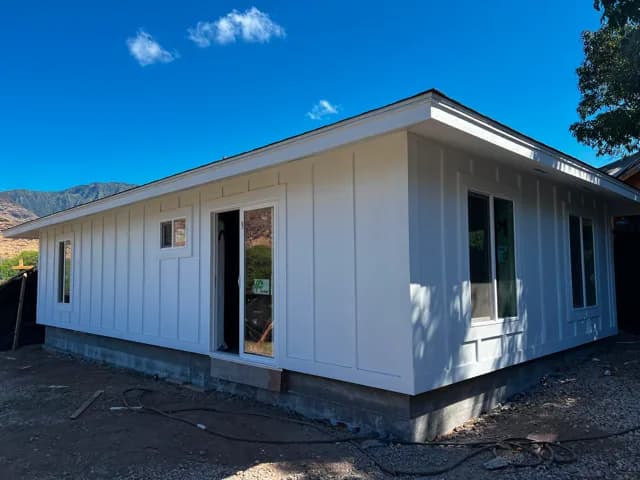 Completed prefab home on Oʻahu with white board-and-batten siding