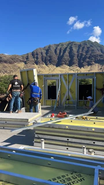 Tall Builders crew raising NABS steel-frame wall panels beneath the Waiʻanae mountains on Oʻahu